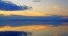 The waters of Morecambe Bay reflecting the mauves and oranges of a sunset.