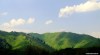 Two visitors enjoy the view of lush, sun-kissed hills in Kazakhstan.